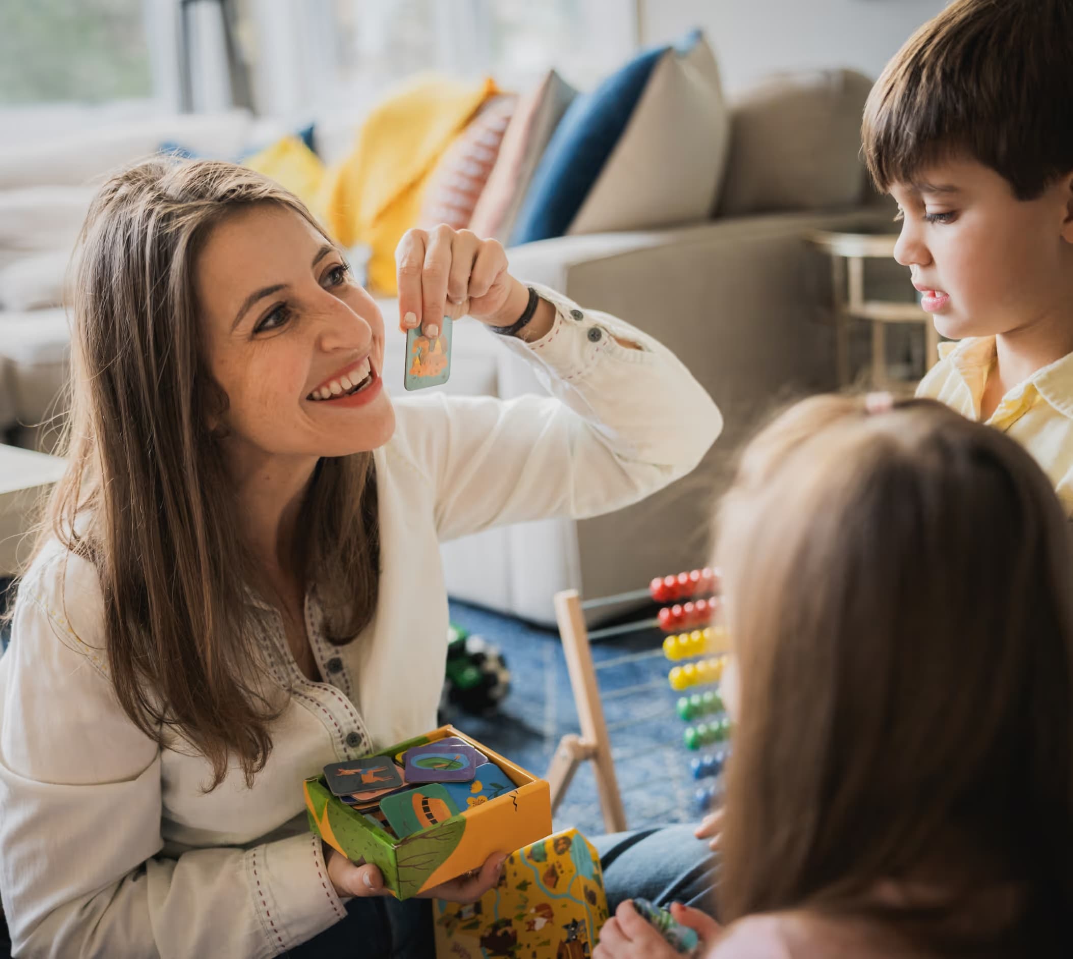 Rosalyn playing a picture-card game with two children at home